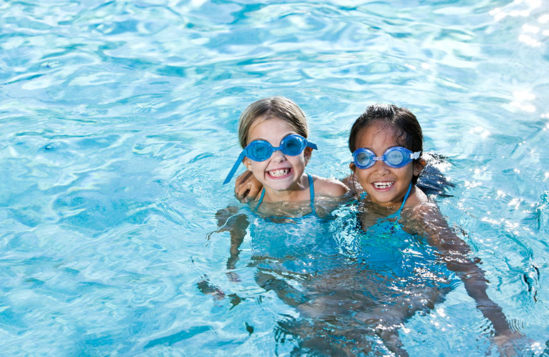 Two girls swimming in pool